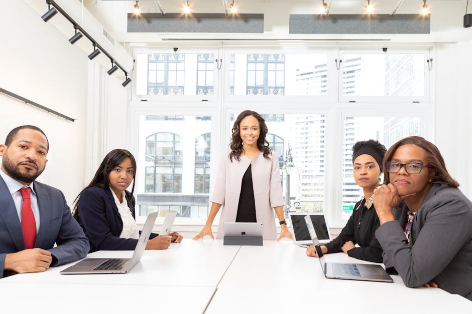 A diverse group of professionals having a meeting in a modern office setting with large windows